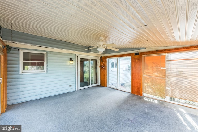 unfurnished sunroom with ceiling fan