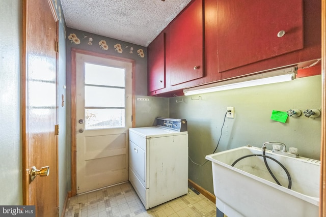 clothes washing area featuring cabinets, washer / clothes dryer, sink, and a textured ceiling