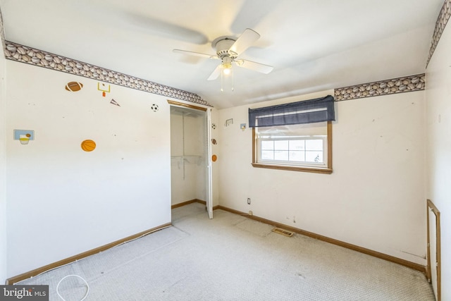 unfurnished bedroom featuring a closet, ceiling fan, light carpet, and vaulted ceiling