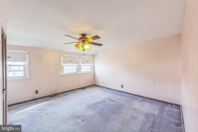 unfurnished room with ceiling fan, carpet flooring, and a wealth of natural light