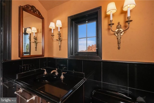 bathroom with tasteful backsplash, sink, and vaulted ceiling