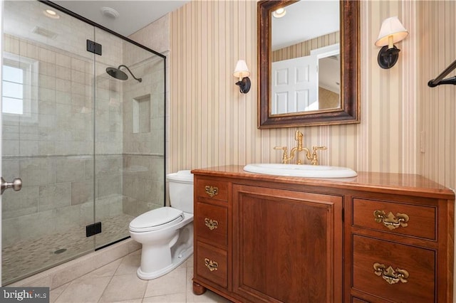 bathroom with vanity, toilet, tile patterned flooring, and a shower with door