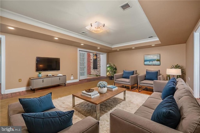 living room with crown molding and a tray ceiling