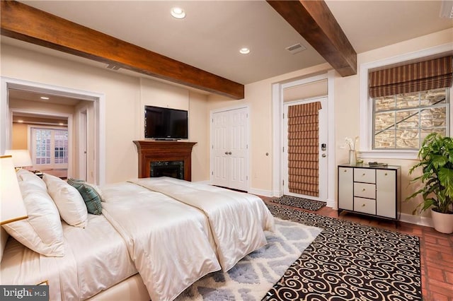 bedroom with multiple windows and beam ceiling