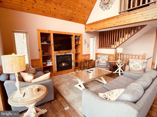 living room featuring high vaulted ceiling, wooden ceiling, a fireplace, hardwood / wood-style floors, and wood walls