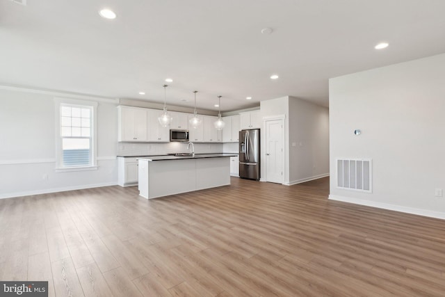 kitchen featuring a center island with sink, white cabinetry, light hardwood / wood-style flooring, and stainless steel appliances