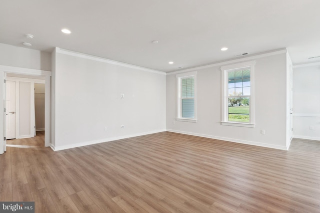 spare room with crown molding and light wood-type flooring