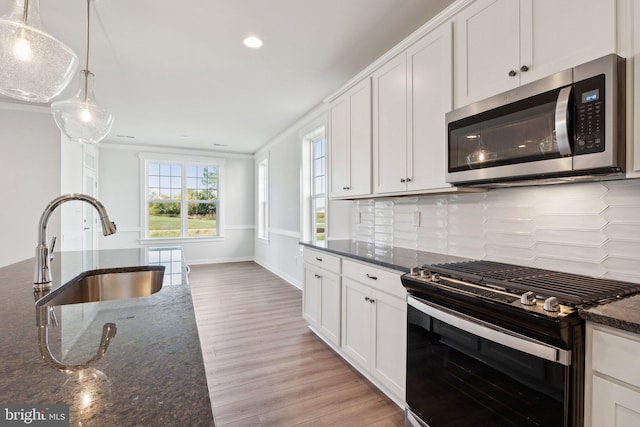 kitchen featuring sink, black range with gas stovetop, white cabinetry, and dark stone countertops