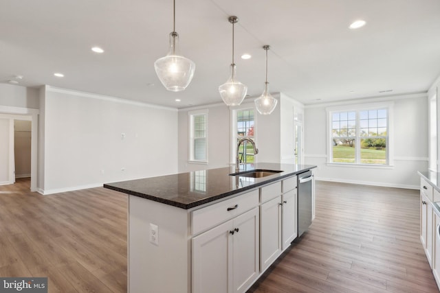 kitchen with sink, a kitchen island with sink, white cabinets, and dark hardwood / wood-style flooring