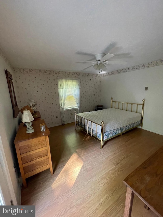 unfurnished bedroom featuring hardwood / wood-style floors and ceiling fan