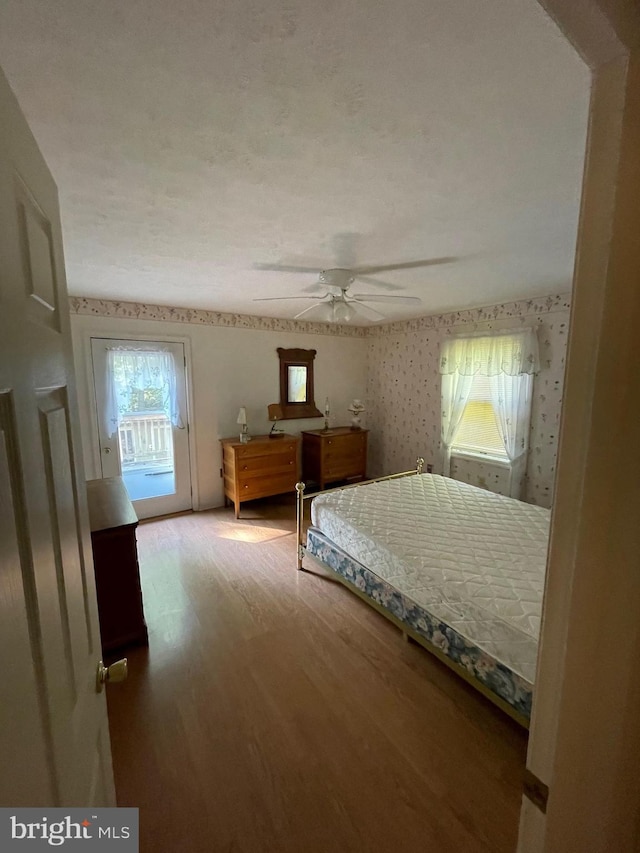 bedroom with hardwood / wood-style floors, access to exterior, and ceiling fan