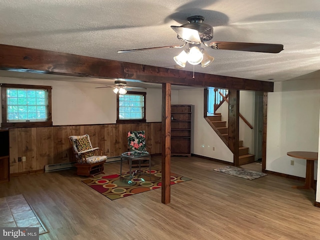 unfurnished room with a textured ceiling, hardwood / wood-style flooring, a healthy amount of sunlight, and ceiling fan