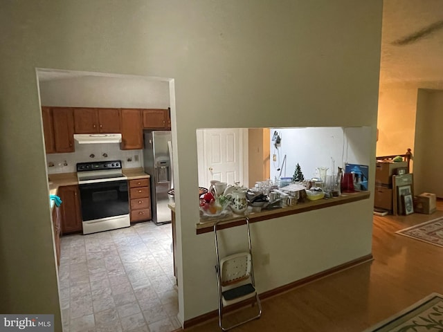 kitchen featuring stainless steel fridge and range with electric cooktop