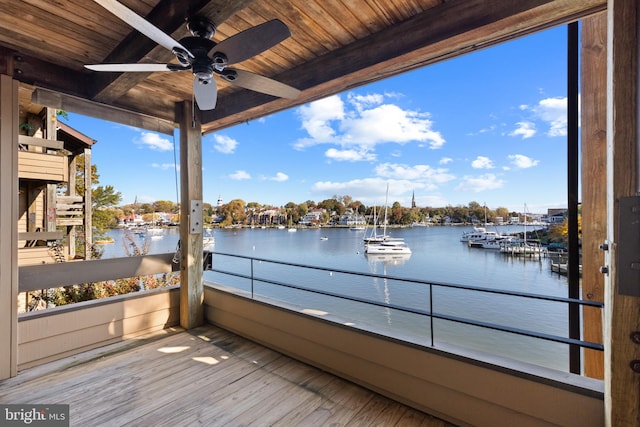 wooden deck with a water view and ceiling fan