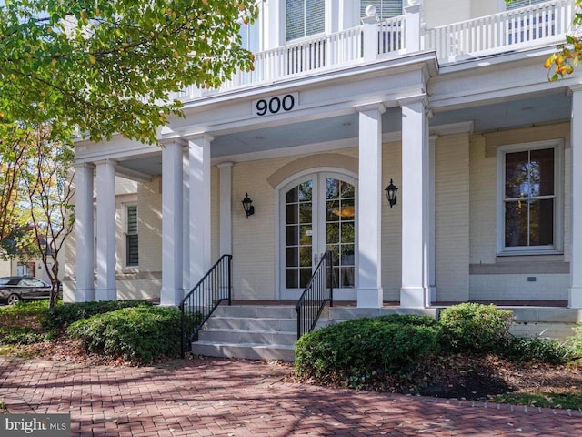 entrance to property with a porch and a balcony