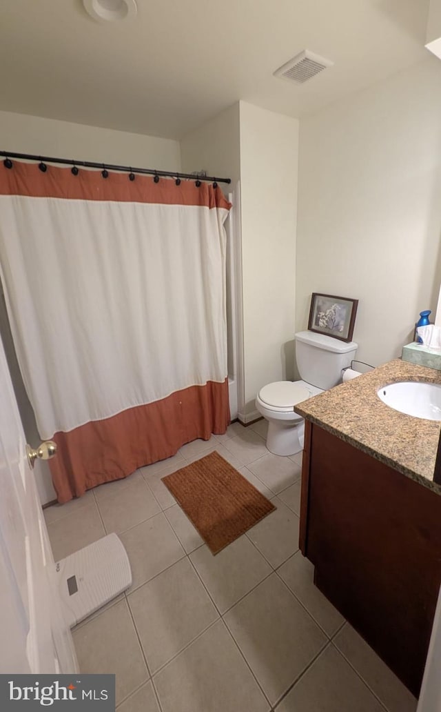 bathroom with tile patterned flooring, vanity, and toilet