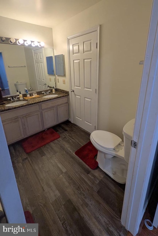 bathroom featuring vanity, wood-type flooring, and toilet