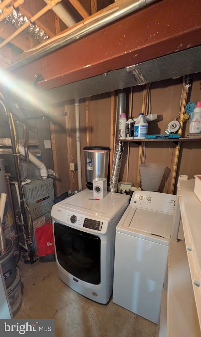 washroom with washing machine and dryer and water heater