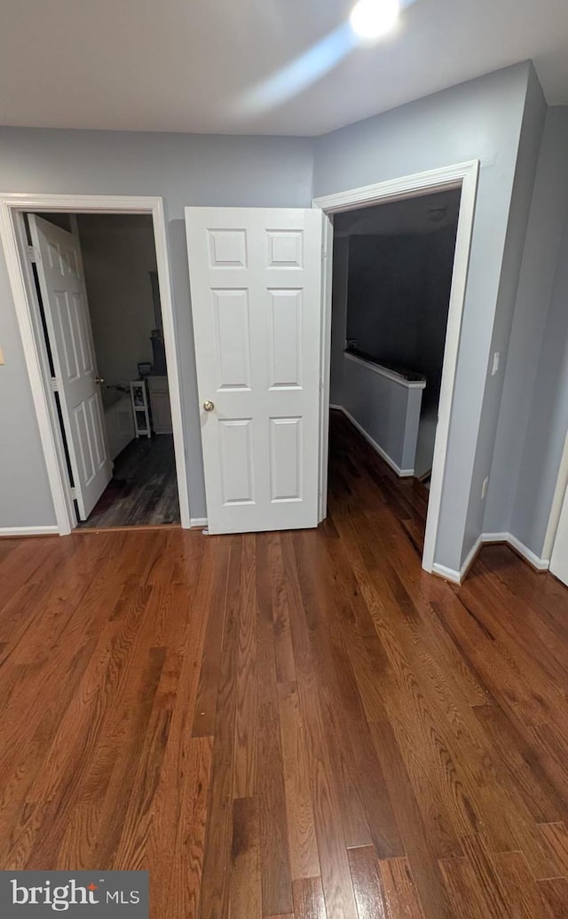 unfurnished bedroom featuring dark wood-type flooring