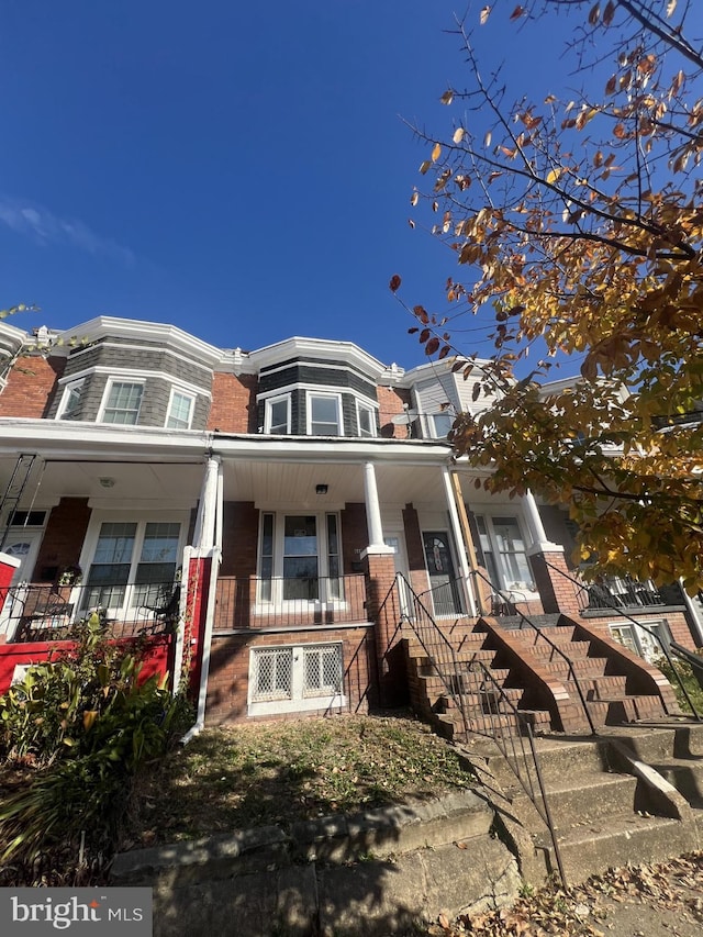 444 E 28th St, Baltimore, MD 21218 - view of front of house with a porch, mansard roof, stairs, and brick siding