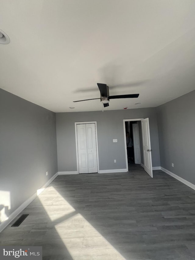 unfurnished bedroom featuring a closet, hardwood / wood-style floors, and ceiling fan