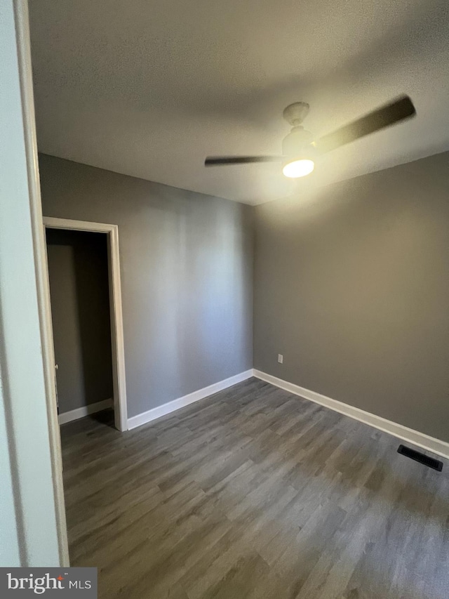 spare room featuring ceiling fan, a textured ceiling, and dark hardwood / wood-style flooring