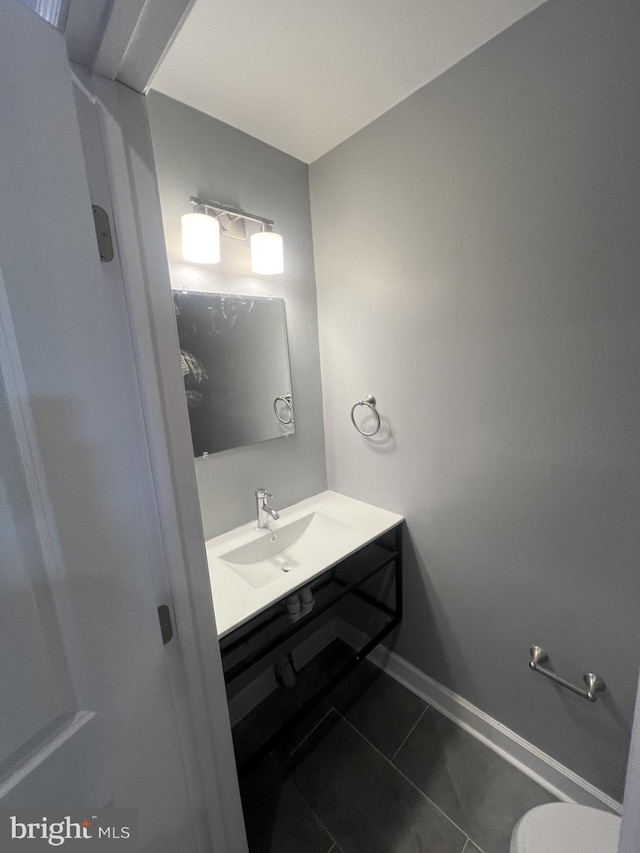 bathroom with vanity, toilet, and tile patterned floors