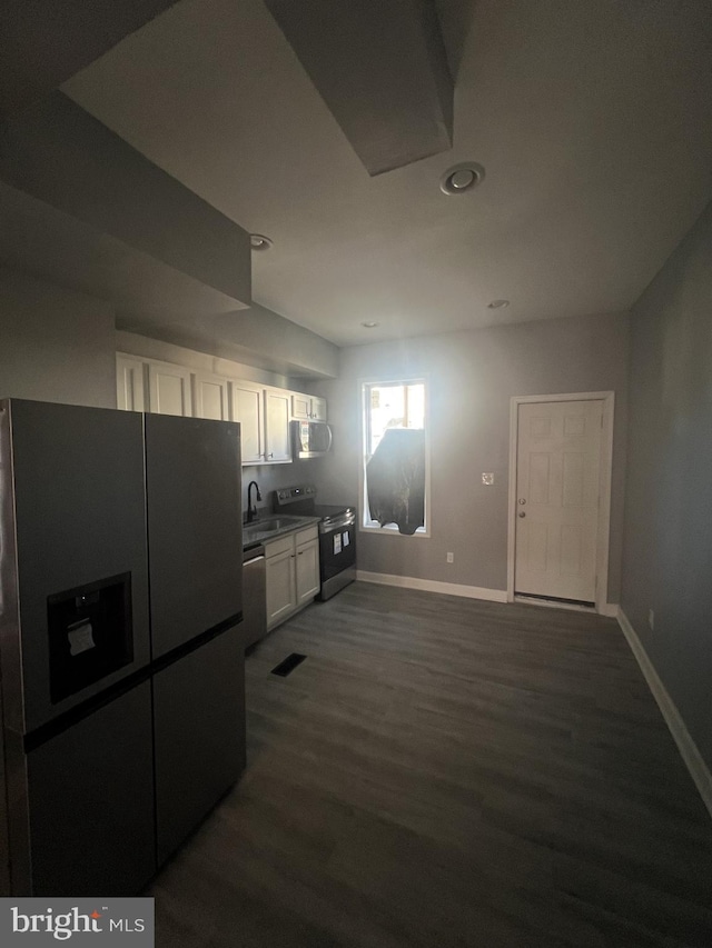 kitchen with white cabinets, stainless steel appliances, dark wood-type flooring, and sink