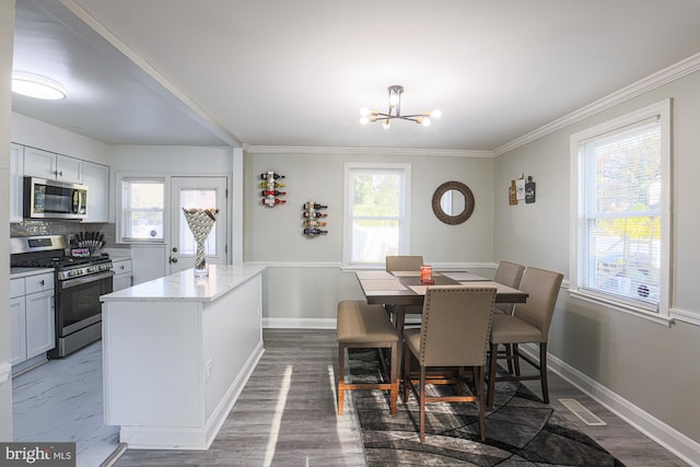 dining space with dark wood-type flooring, a notable chandelier, and ornamental molding