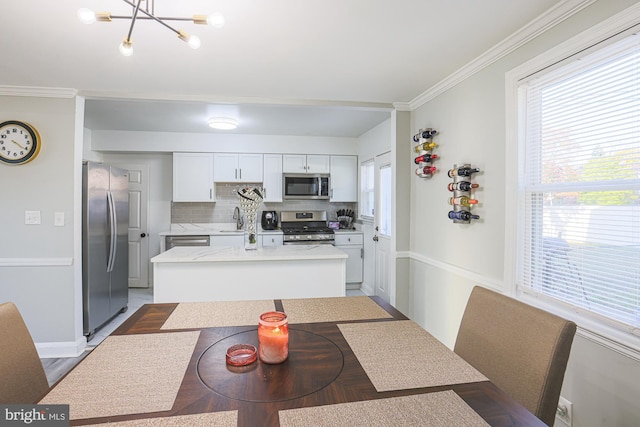 kitchen with white cabinetry, backsplash, appliances with stainless steel finishes, and a healthy amount of sunlight