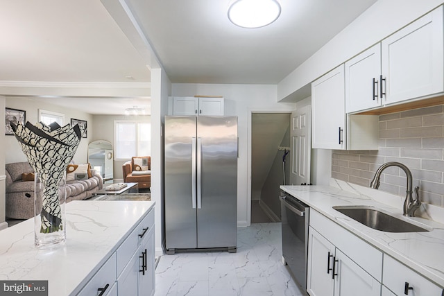 kitchen featuring tasteful backsplash, light stone counters, stainless steel appliances, white cabinetry, and sink