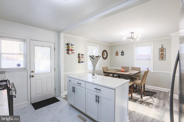 kitchen featuring a wealth of natural light, stainless steel range with electric cooktop, light stone counters, and crown molding