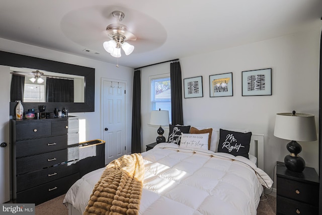 carpeted bedroom featuring ceiling fan and a closet