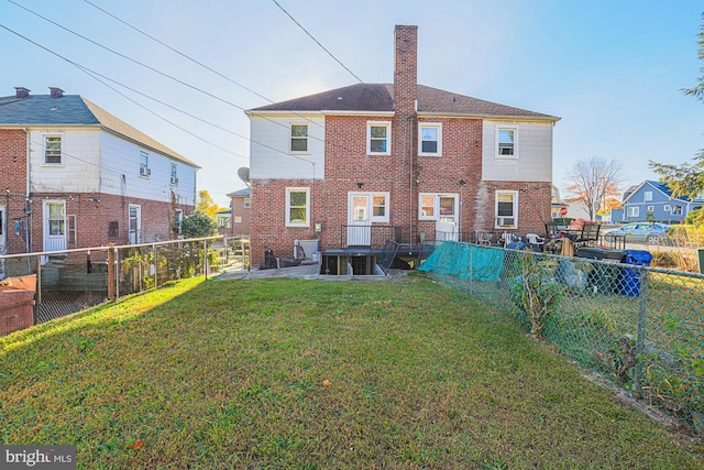 rear view of house featuring a patio and a lawn