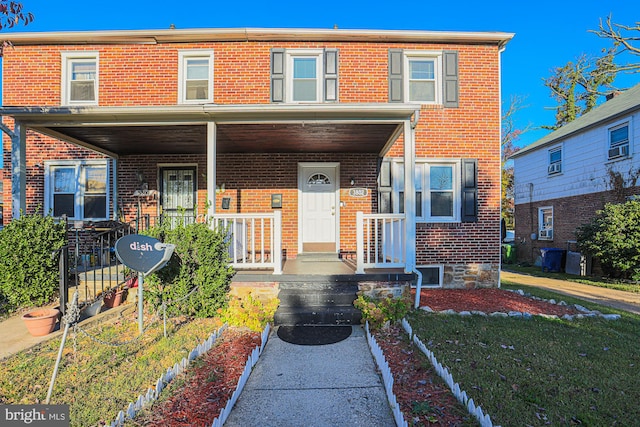 multi unit property featuring a front lawn and covered porch