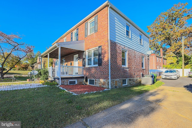 view of side of property with a lawn and covered porch