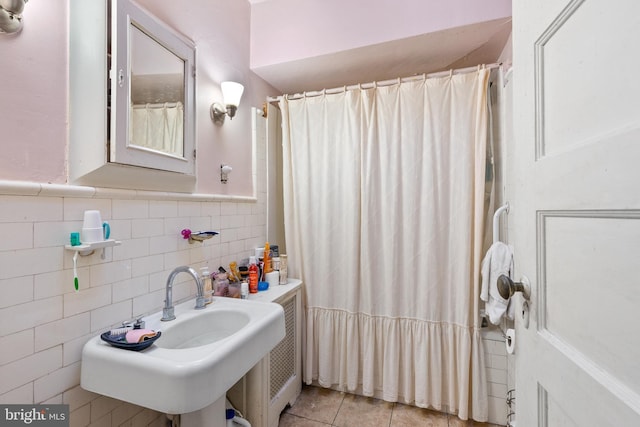 bathroom with tile patterned floors, sink, and tile walls