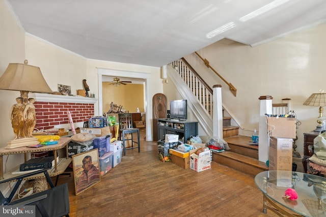 living room with hardwood / wood-style flooring, ceiling fan, and ornamental molding