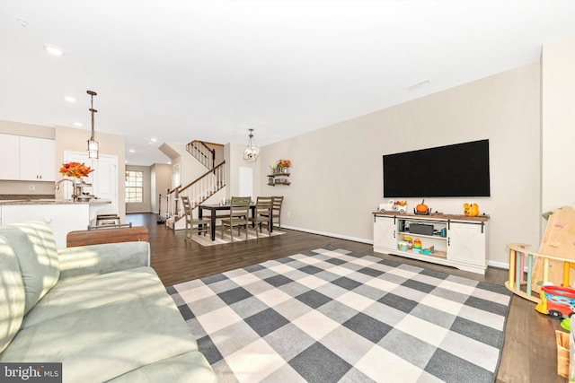 living room featuring a chandelier, dark wood-type flooring, and sink