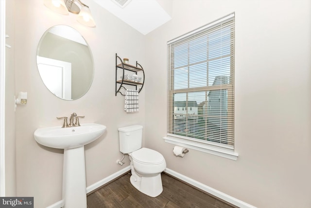 bathroom featuring toilet, lofted ceiling, wood-type flooring, and sink