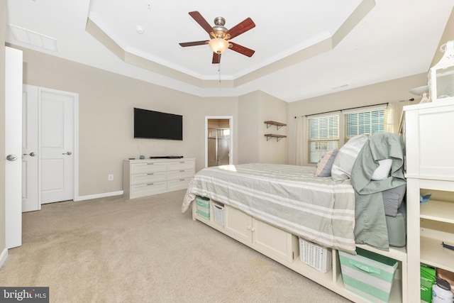 carpeted bedroom featuring crown molding, a raised ceiling, and ceiling fan