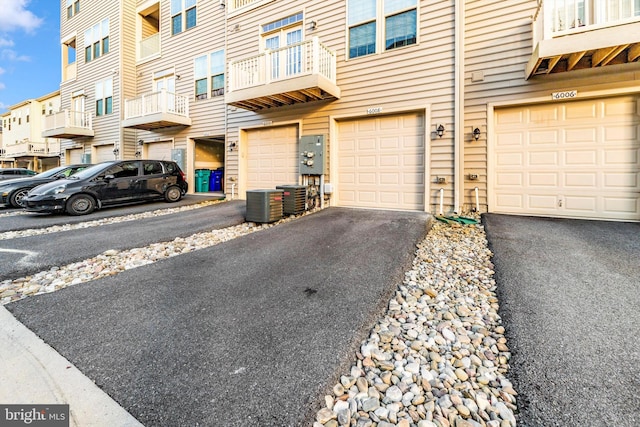 exterior space featuring a balcony, a garage, and central air condition unit