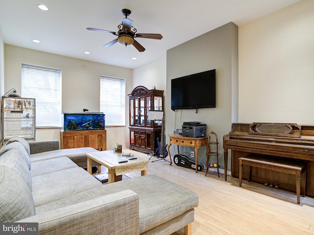 living room with light wood-type flooring and ceiling fan