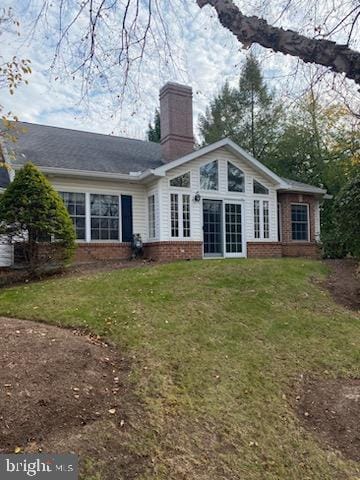 back of house with a lawn