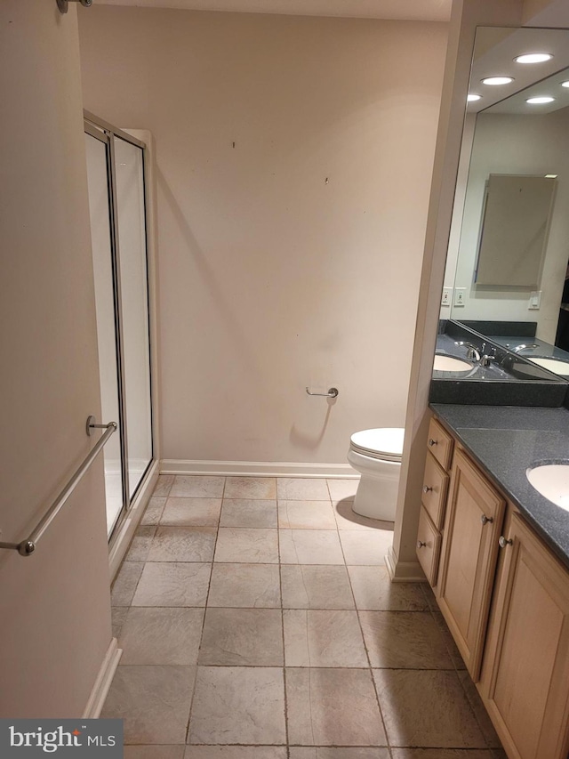 bathroom featuring vanity, toilet, and a shower with door