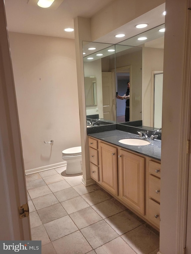 bathroom with vanity, toilet, and tile patterned floors