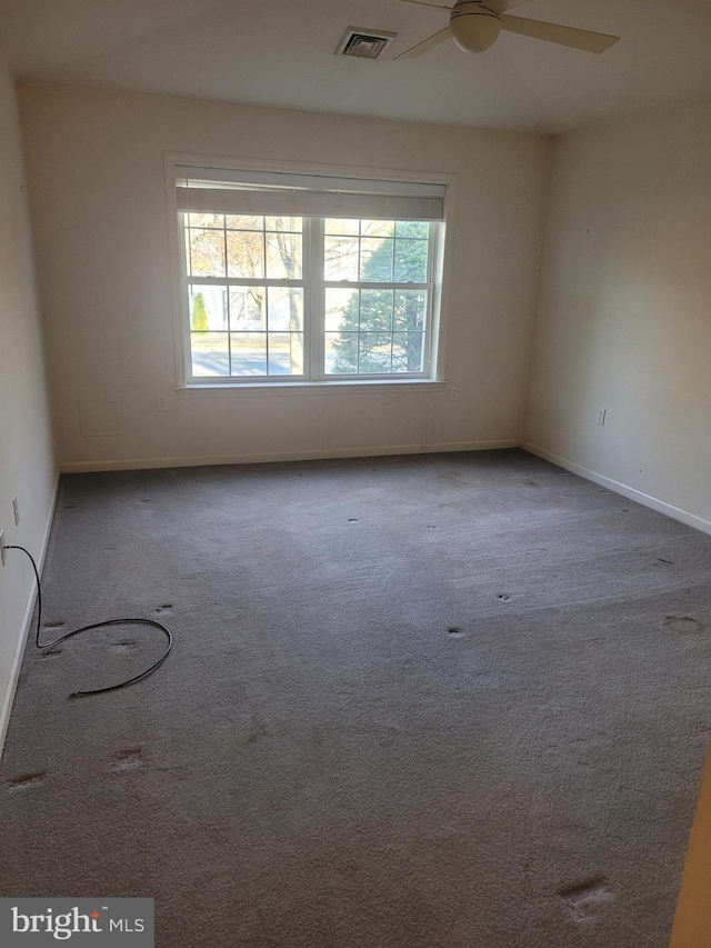 carpeted spare room featuring ceiling fan