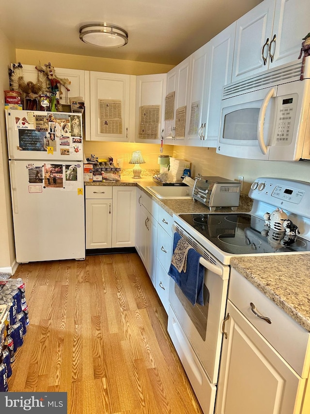 kitchen with light hardwood / wood-style flooring, sink, white cabinetry, light stone counters, and white appliances