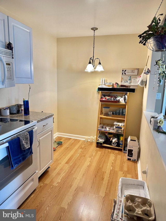 kitchen with white cabinets, an inviting chandelier, light hardwood / wood-style flooring, pendant lighting, and white appliances