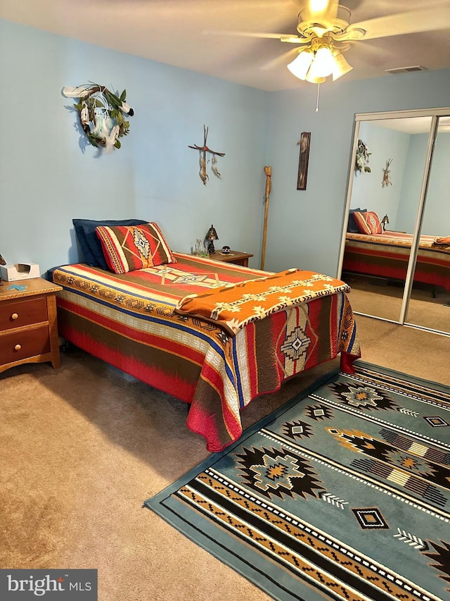 carpeted bedroom featuring a closet and ceiling fan